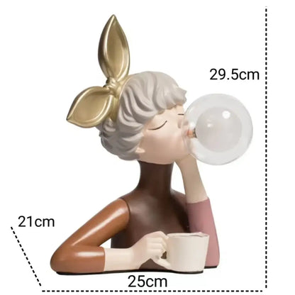 A charming decorbites bubble girl resin figurine with gray hair and gold bow blowing a bubble holding a white mug