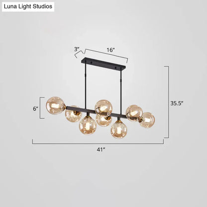 DecorBites™ bubbles glass pendant light features a modern black metal frame with seven amber glass globe bulbs for dining