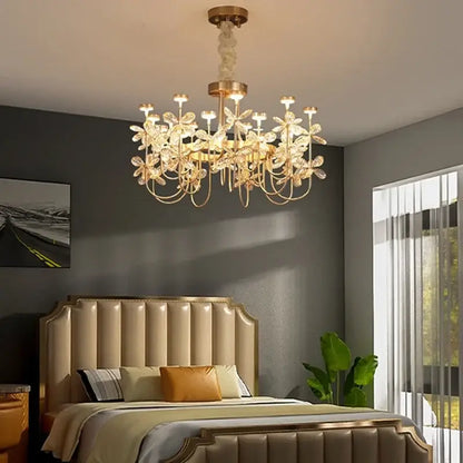 Gold-toned decorbites butterfly chandelier with crystal flower accents hanging above a bed in a dining room setting