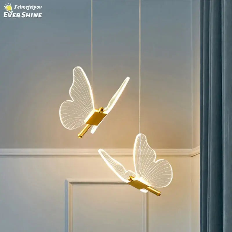 Two elegant translucent butterfly pendant lights with gold metallic bodies by decorbites for dining room lighting