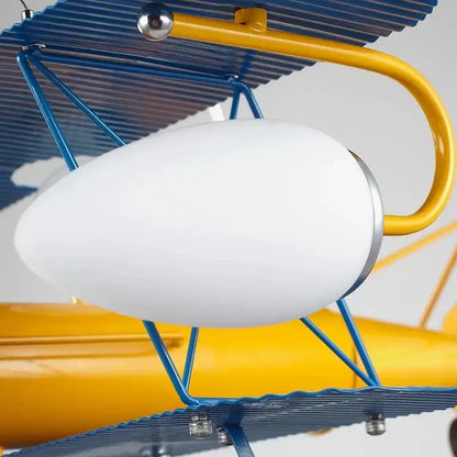 A decorbites cartoon aircraft fan light features a white oval glass lampshade with silver rim on blue and yellow biplane fixture