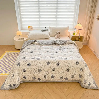Cream velvet quilted blanket with decorbites cartoon print featuring gray and black bears and soft textured surface