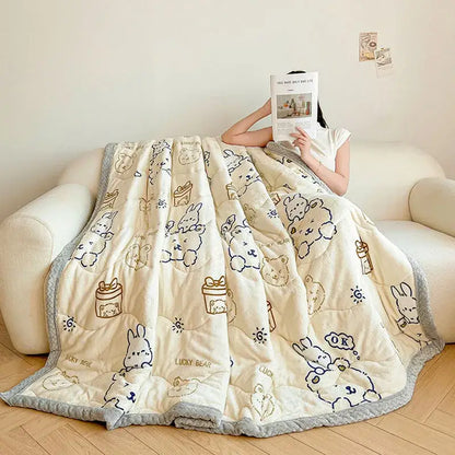 Cream velvet quilted blanket with plush texture and decorbites cartoon print featuring bunnies and gift boxes in navy and gold