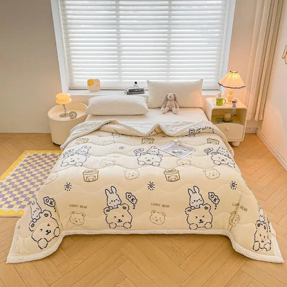 Cream-colored velvet quilted blanket with decorbites cartoon print featuring bears and bunnies holding gifts