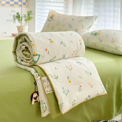 A soft rolled-up decorbites cartoon summer cotton blanket with pastel floral pattern for bedroom bedding use