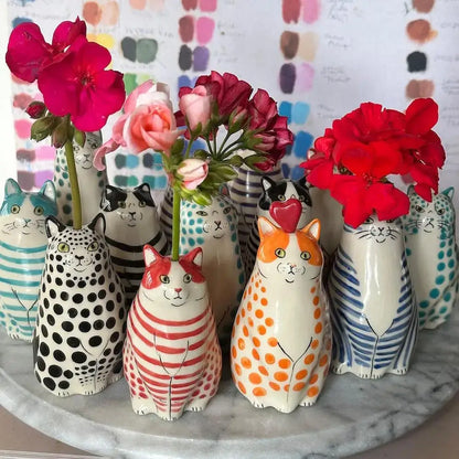A collection of decorbites™ cat polka dot resin flower bud vases with colorful patterns and painted facial features
