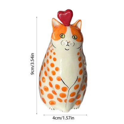 A charming orange and white polka dot cat vase made of resin with a glossy finish and a red heart topper
