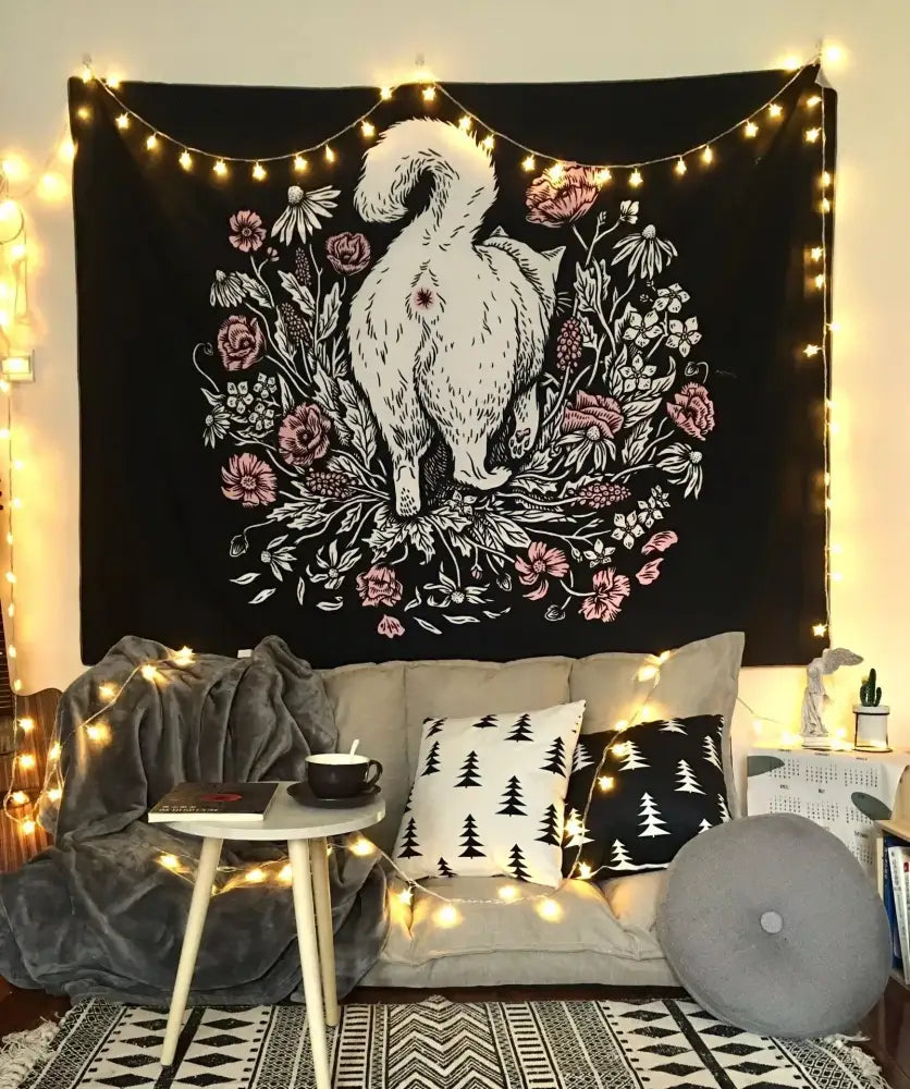 Decorbites cat witchcraft black rose tapestry featuring white cat and pink flowers hanging above a cozy sofa