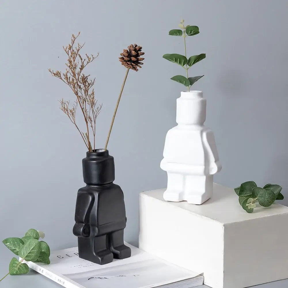 Black and white ceramic robot vase shaped like lego minifigures with dried plants for nordic style decor