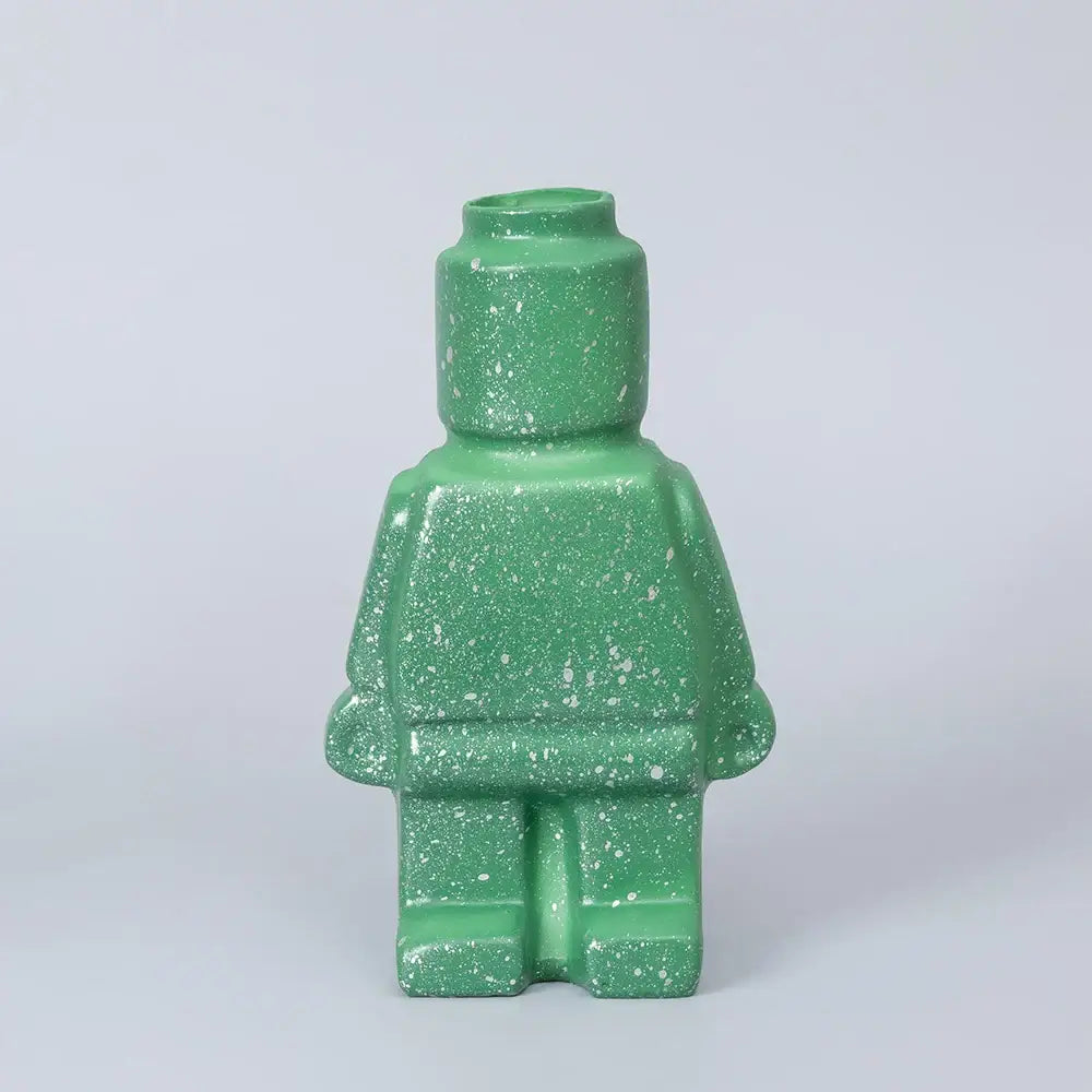 A green speckled ceramic robot vase shaped like a lego minifigure in nordic style home decor by decorbites
