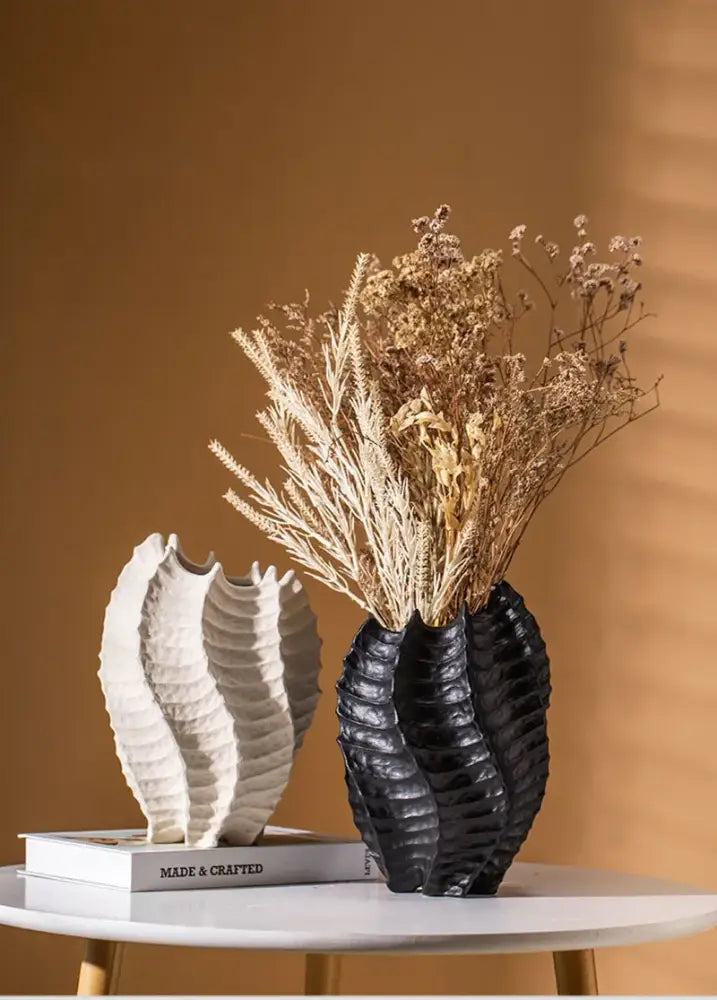 Black ceramic sea vase with ridged shell-like texture holding dried botanicals for nordic modern decor