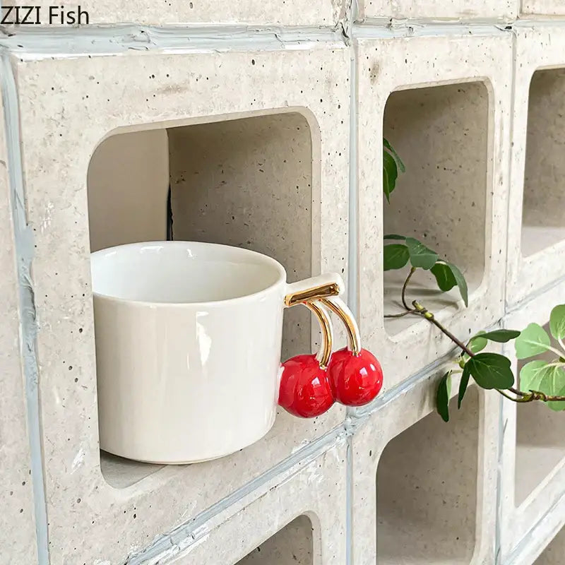 White ceramic tea and coffee cup with a gold cherry handle mug by DecorBites for dining table use