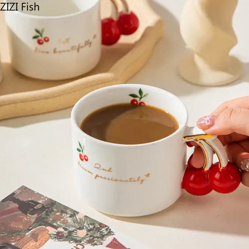 White ceramic porcelain coffee mug with cherry pattern porcelain design gold lettering and red cherry handle detail