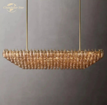 Gold-toned decorbites chiara smoke glass tiered chandelier with modern elongated design and faceted amber glass pieces