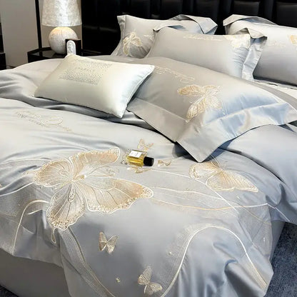 Light blue satin bedding set with intricate gold-threaded butterfly embroidery and lace from DecorBites chic embroidered cotton collection