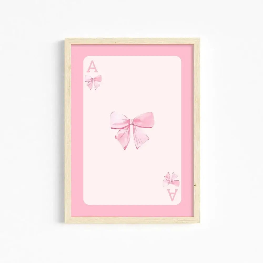 A framed pink wall art print by decorbites featuring a watercolor bow design for girls wall decor