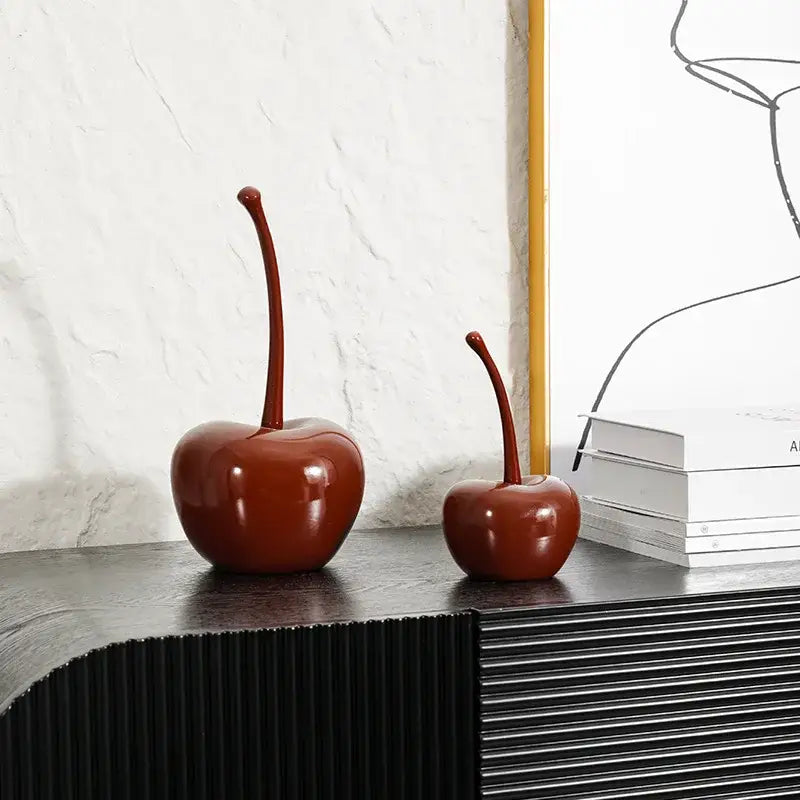 Two glossy deep red chic red cherries resin ornaments from decorbites sit on a dark surface for home decor