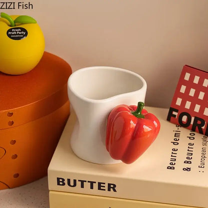 A glossy red ceramic decorbites chili handle cup with green stem and white handle sitting on stacked books