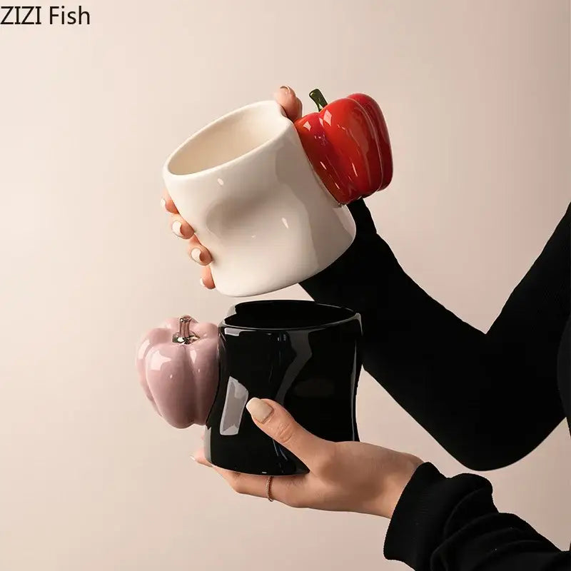 A glossy porcelain decorbites chili handle cup with red pepper-shaped lid and a black chili handle cup with smooth curves