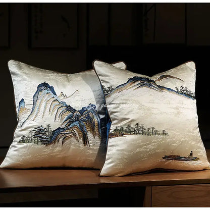 Cream-colored silk pillow cover with chinoiserie landscape embroidered in blue brown and gold mountain and pine designs