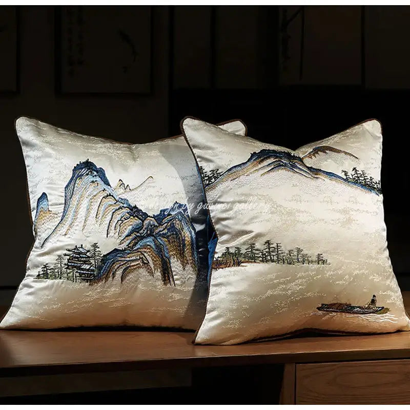 Cream-colored silk pillow cover with chinoiserie landscape embroidered in blue brown and gold mountain and pine designs