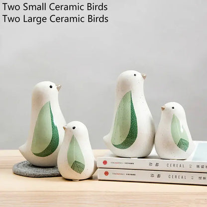 White ceramic bird figurines with green leaf-patterned wings and speckled finish for home decor by DecorBites bird figurines