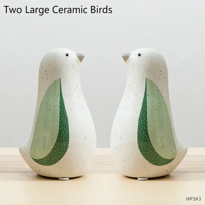 Two large ceramic bird figurines with speckled white bodies and green wing accents for home decor by DecorBites bird figurines