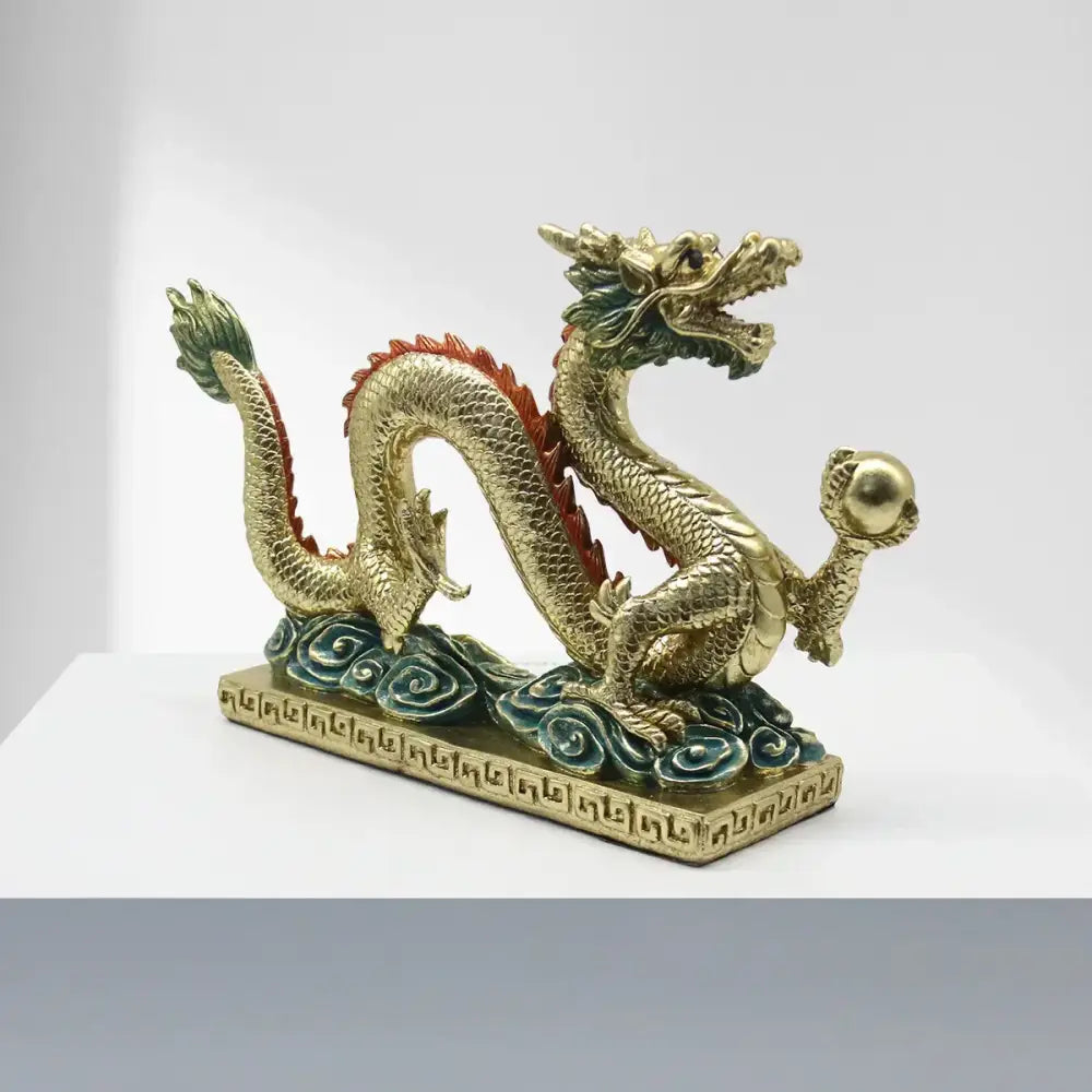 Golden resin sculpture of a decorbites chinese dragon with red and green accents and an ornate base for home decor