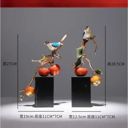 Two enamel persimmon ruyi bird sculptures with blue and white birds and red fruit on black marble bases for décor