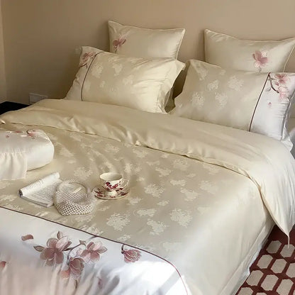 Cream-colored satin bedding set with pink floral embroidery and white accents made from lyocell cotton by DecorBites Chinese Floral