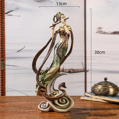 Detailed resin chinese goddess fairy figurine in green and gold robe playing flute on swirling clouds home decor piece