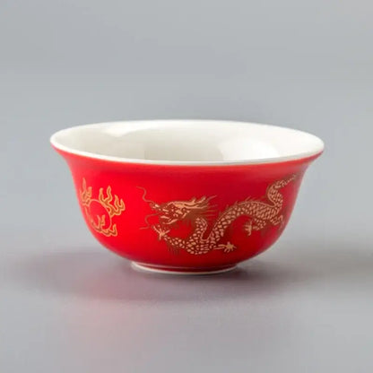 A vibrant red porcelain tea cup with golden dragon and cloud motifs from decorbites vintage dragon tea cup set
