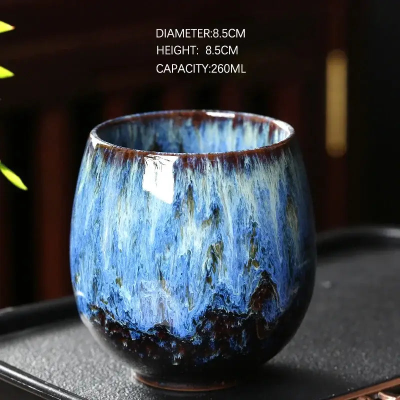 Handcrafted ceramic coffee cup with vibrant blue and brown glaze featuring swirling patterns from decorbites™