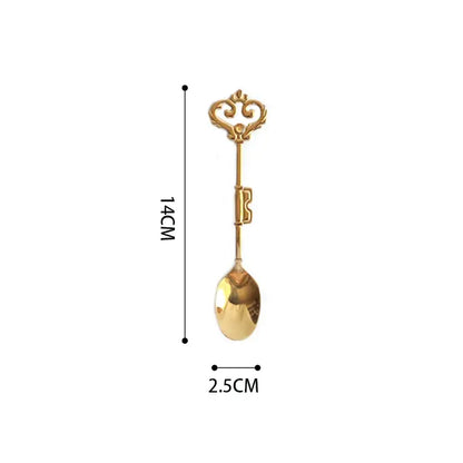 A golden key-shaped spoon with an ornate vintage handle and polished metal finish for decorbites chinoiserie floral birds dinner