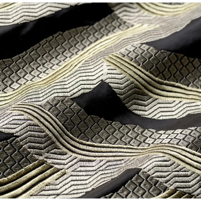 Black and metallic gold embroidered fabric with intricate geometric wave patterns on decorbites chinoiserie golden cushion cover