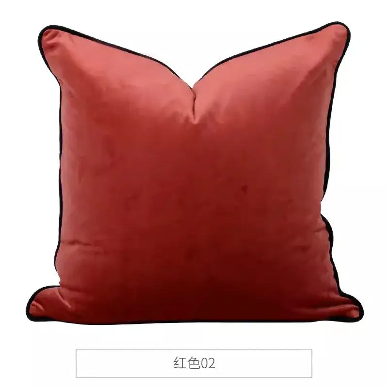 A coral-red velvet throw pillow with black piping trim from decorbites chinoiserie monkey umbrella peonies collection