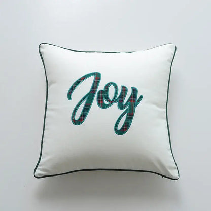 White square pillow cover with embroidered joy in teal and red plaid framed by dark green piping decorbites christmas cartoon letter