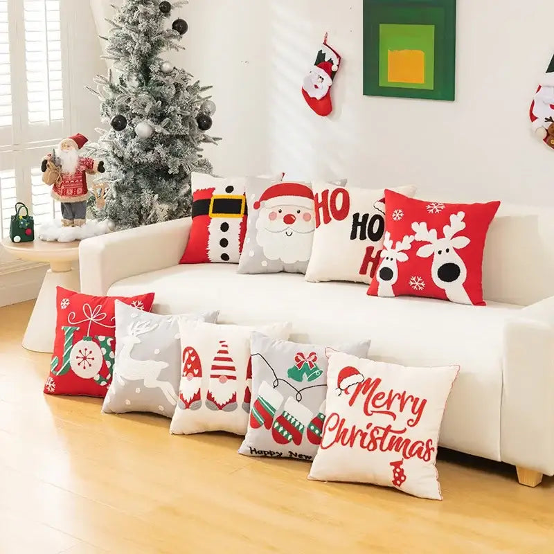 A collection of decorbites christmas cartoon pillow covers in red white and gray with embroidered festive designs and greetings
