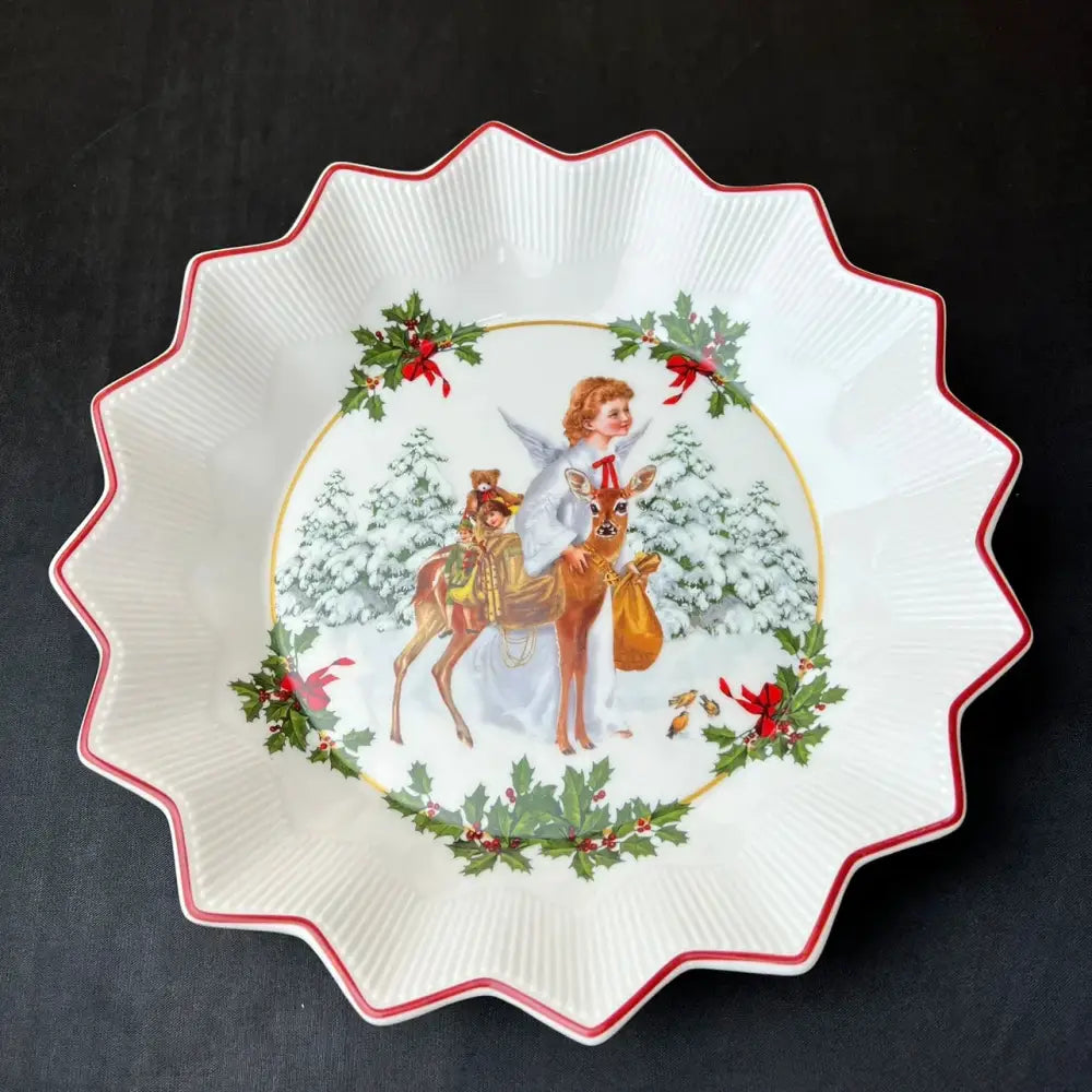 White ceramic holiday bowl with red scalloped rim and painted angel riding deer scene from decorbites christmas dinnerware set