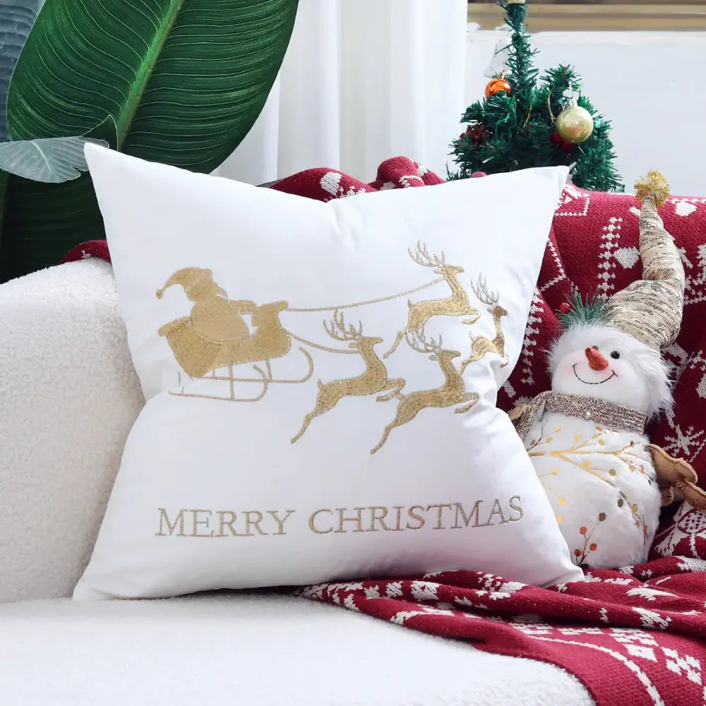 White christmas-themed pillow cover with gold glittery santa sleigh embroidery and merry christmas text from DecorBites christmas elk collection
