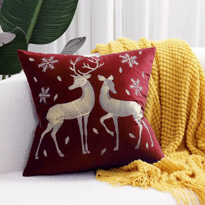 A plush burgundy velvet pillow cover with embroidered silver christmas elk and snowflake patterns by decorbites christmas elk