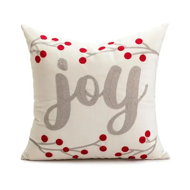 Cream-colored pillow cover with decorbites christmas embroidered joy in silver thread and red berry accents on gray branches