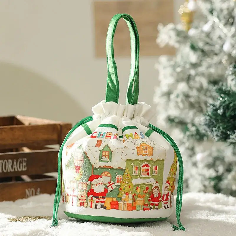 A festive white DecorBites Christmas Eve apple bag with green trim and a colorful Christmas village print