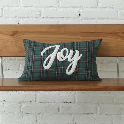 A rectangular green plaid pillow with white cursive christmas letter embroidery spelling joy from decorbites christmas letter set