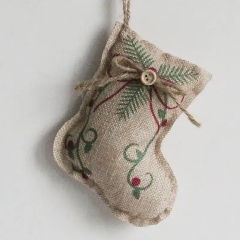 A rustic beige burlap christmas linen pendant featuring green pine needle and red berry embroidery with a printed pentagram sock design