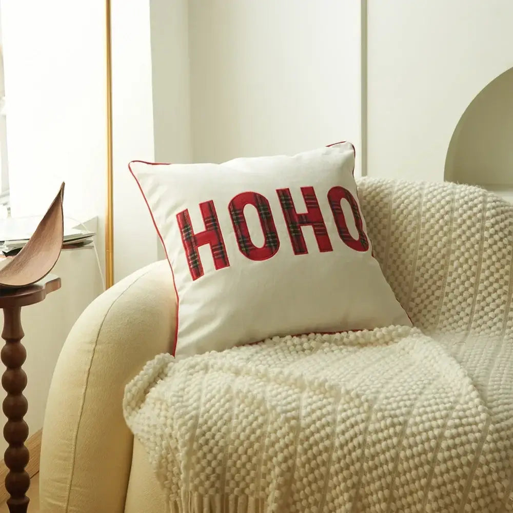 White pillow with red plaid print ho ho lettering and stitched border in decorbites christmas plaid pillow case set