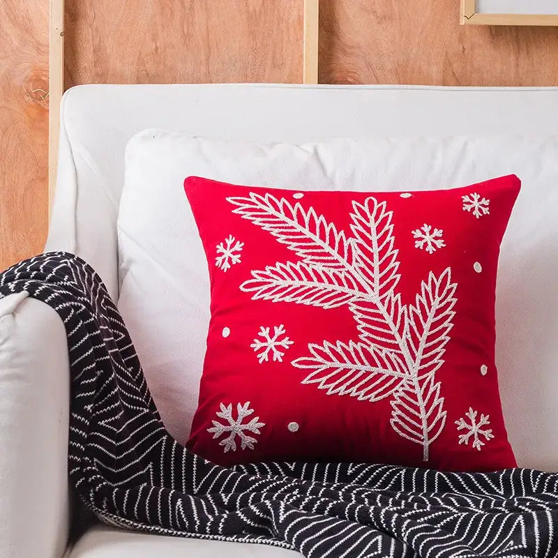 Red cushion with white embroidered pine branches and snowflakes from decorbites christmas snowflake elk pillowcases
