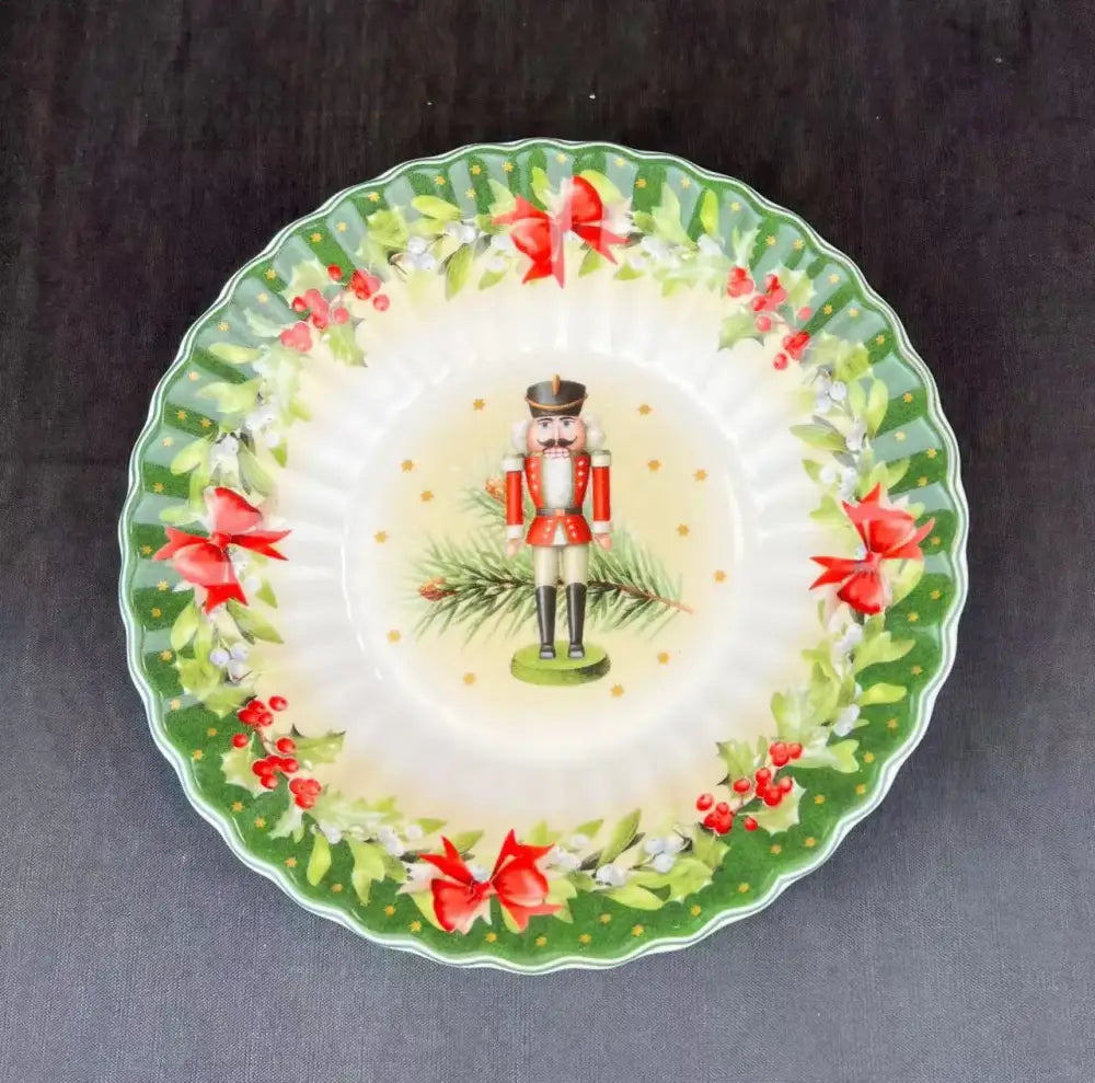 A festive ceramic plate from DecorBites Christmas tableware featuring a nutcracker and holly design on its rim