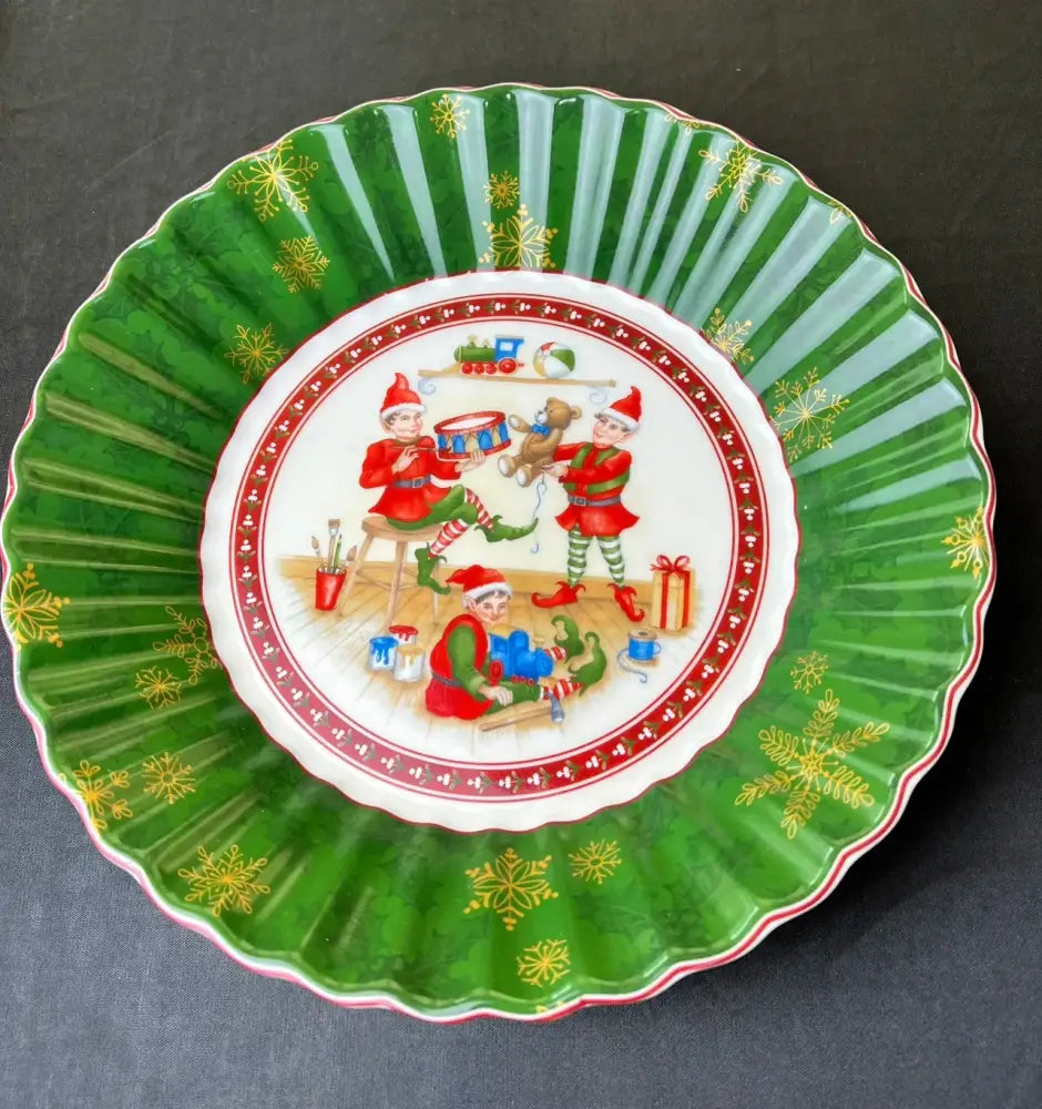 Green ceramic christmas plate with scalloped edges featuring elves crafting and playing music in decorbites christmas tableware set