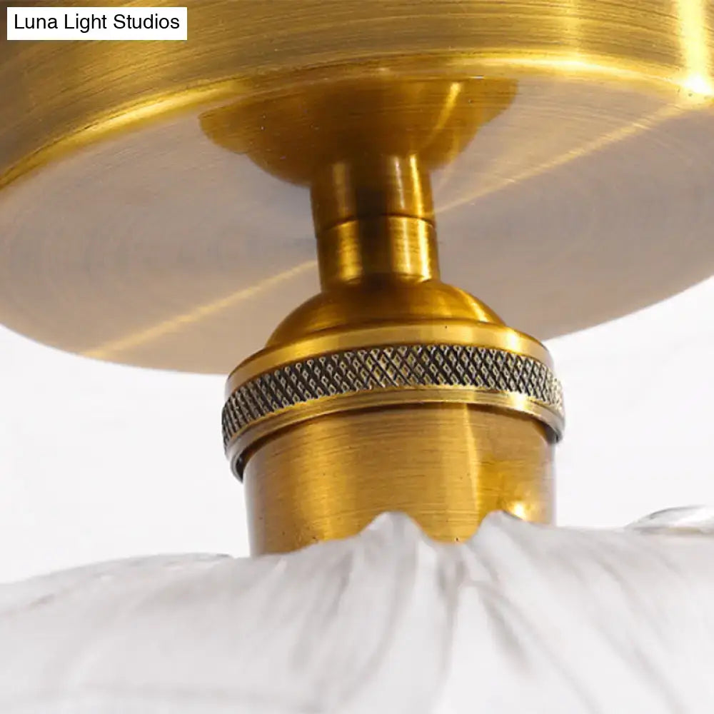 Brass-finished table lamp with a textured metallic band and white fabric shade paired with a glass ceiling light fixture featuring a brass lamp holder